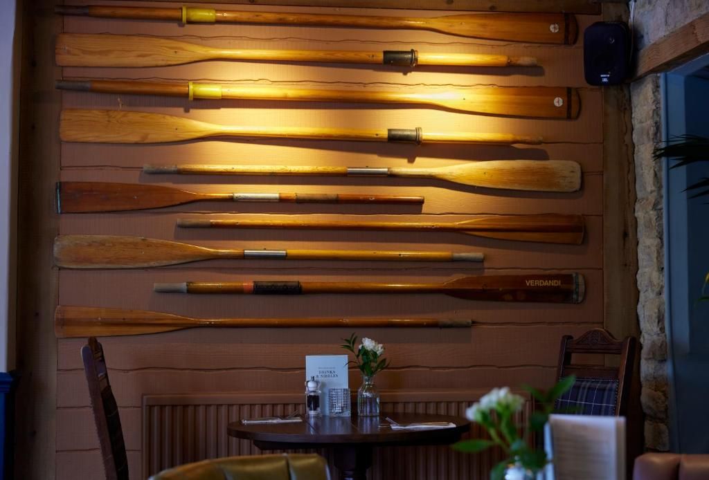 A wall with various wooden paddles displayed horizontally.