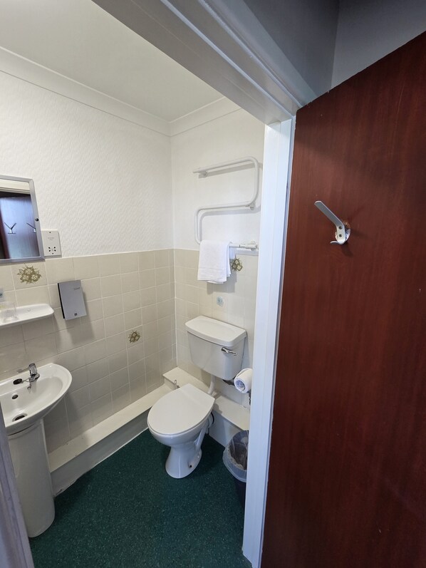 Ein kleines Badezimmer mit Toilette, Waschbecken und Spiegel.