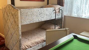 Relax in this well-appointed room featuring a bunk bed and pool table, perfect for recreation and rest.