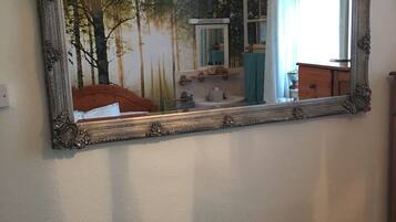 A mirror with an ornate frame on a wall.