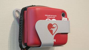 A red defibrillator with a heart symbol and the text "HEARTSTART DEFIBRILLATOR" on it.