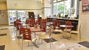 A cafeteria with tables and chairs, vending machines, and a window with a view of the outside. - Toyoko Inn Kobe Minatogawa Koen (HYOGO)
