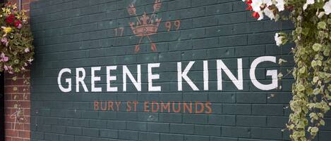 A wall with the name "GREENE KING" and "BURY ST EDMUNDS" painted on it.