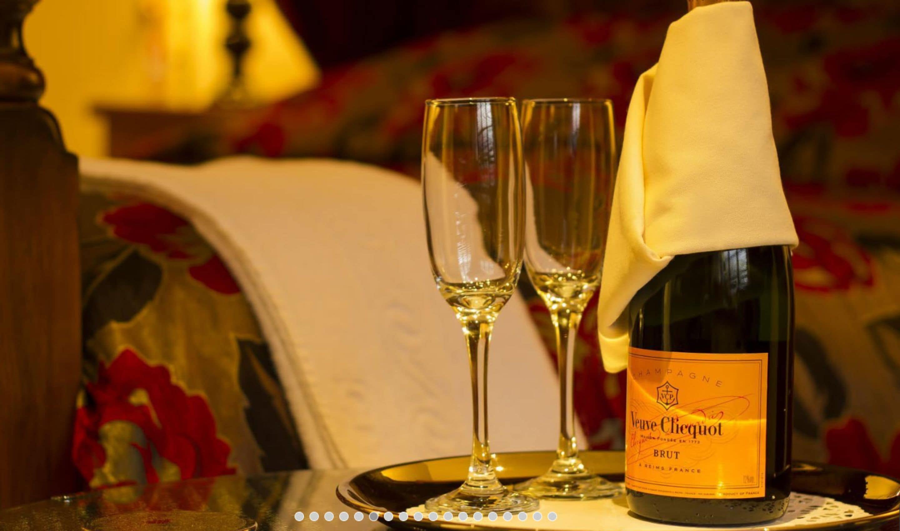 En flaska Veuve Clicquot Brut-champagne på ett bricka tillsammans med två glas.