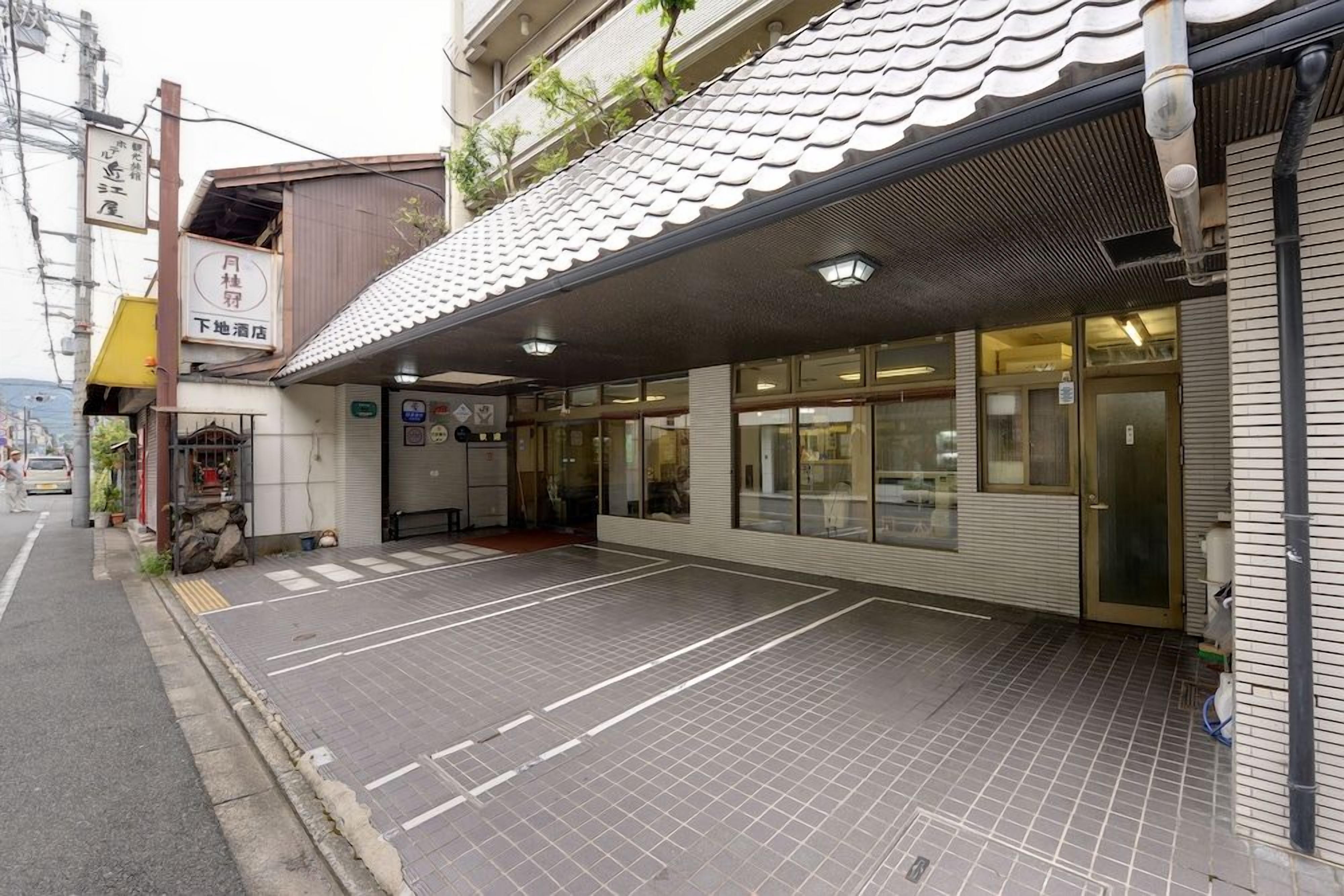 Un edificio con techo de tejas, vestíbulo cubierto y estacionamiento.