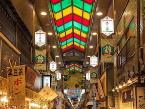 Rua estreita com sinalização tradicional e lanternas, indicando uma área cultural ou histórica.