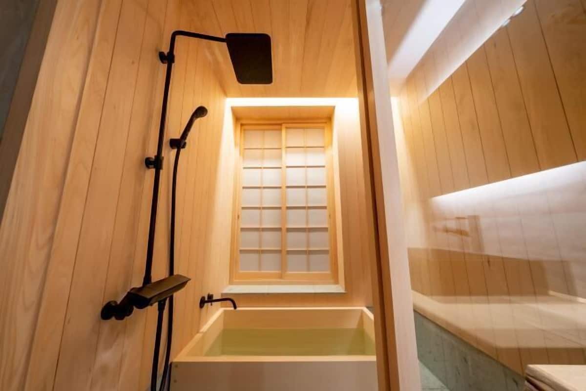 Badkamer | Een aparte badkuip en douche, een regendouche, gratis toiletartikelen