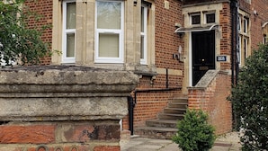 A brick residential building with a sign reading "NOA Residence" and the number "200" on the wall. - Noa Residence (Oxford)