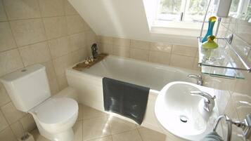 A bathroom with a toilet, bathtub, and sink.
