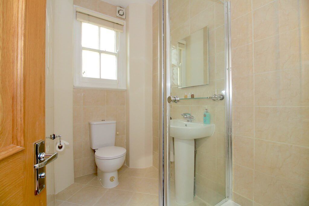 A bathroom with a toilet, a sink, and a glass shower enclosure.