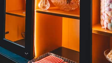 A kitchen with a black countertop, a glass baking tray, and a hanging pot rack.