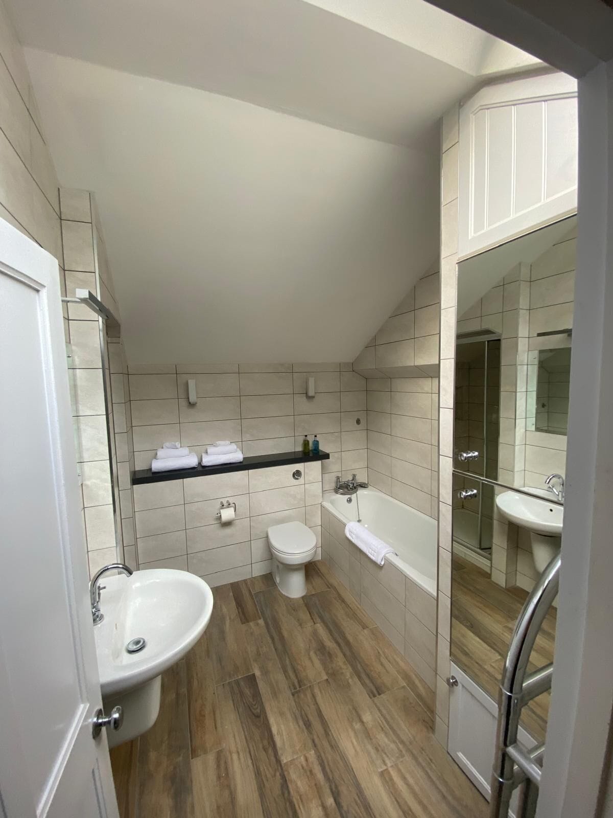 A modern bathroom with a freestanding bathtub, a sink, and a toilet.