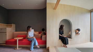 A modern interior with a red sofa, a small round table, and a wooden bench.