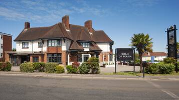 Experience the traditional charm of the Shah of Persia building, a historic pub or restaurant with a distinctive pitched roof and brick exterior.