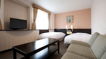 A hotel room with two beds, a TV, a bedside table, a sofa, and a painting on the wall.