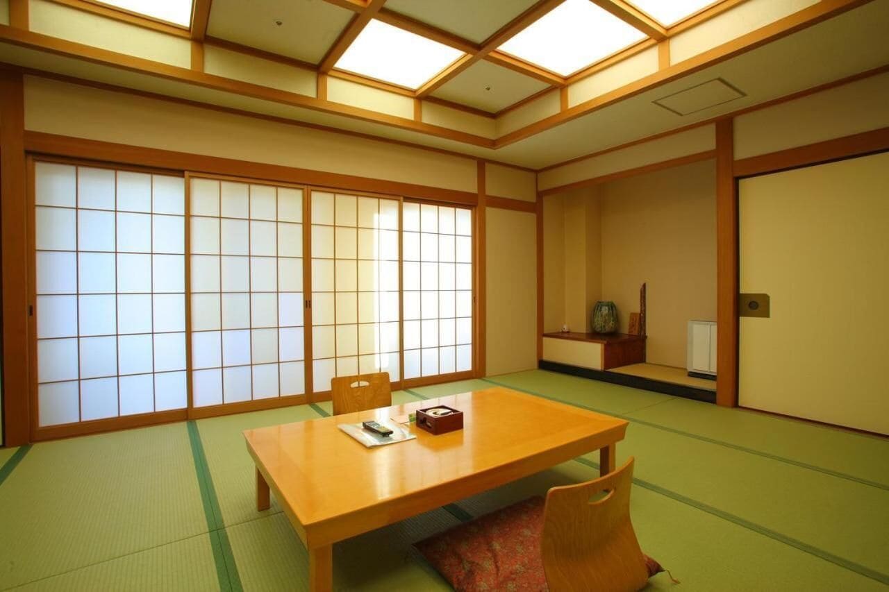 A traditional Japanese room with tatami flooring, a low wooden table, and sliding shoji doors.