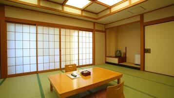 A traditional Japanese room with tatami flooring, a low wooden table, and sliding shoji doors.