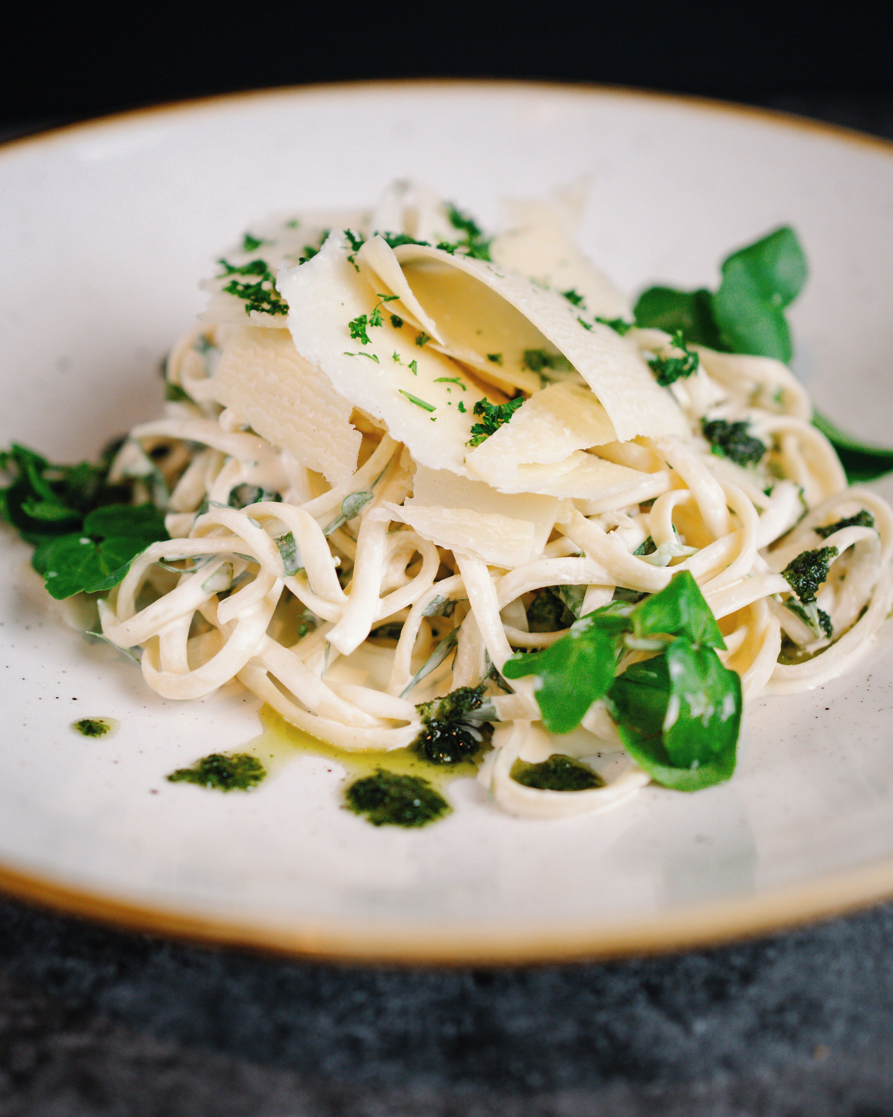 Un plato de pasta con queso y hierbas.