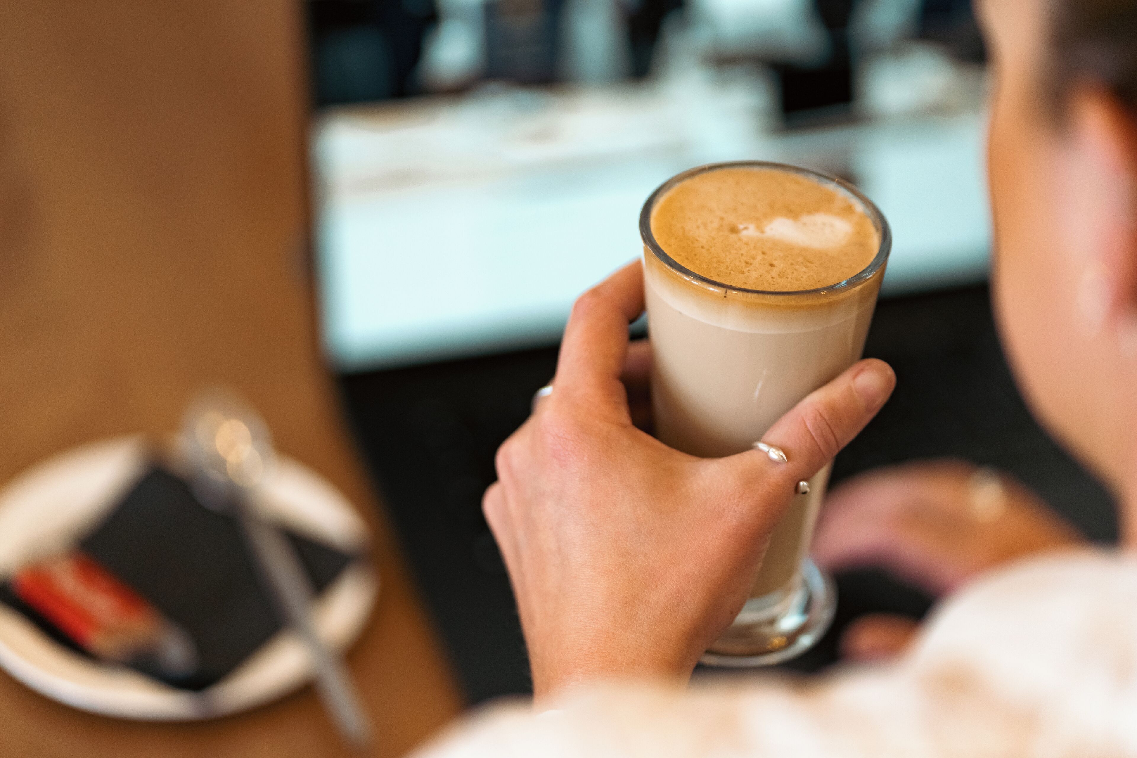 A person holding a glass of coffee.
