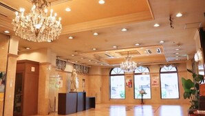 A spacious lobby with a chandelier, large windows, and a statue. - Hotel Sun Valley Annex (Beppu)
