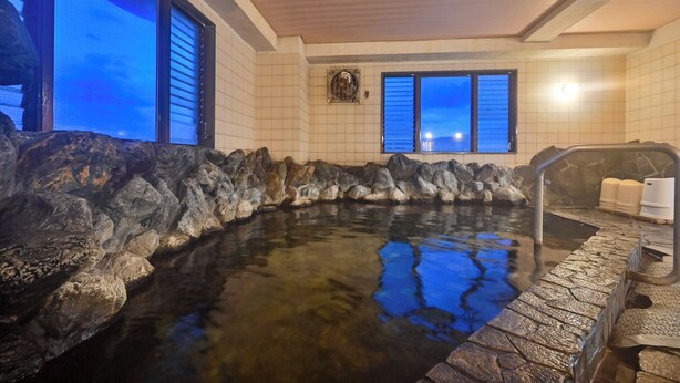A hot spring area with a stone wall, a window with blinds, and a tiled ceiling. - Hotel Sun Valley Annex (Beppu)