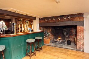 Relax by the rustic fireplace in our inviting bar area, featuring a selection of beverages and comfortable seating.