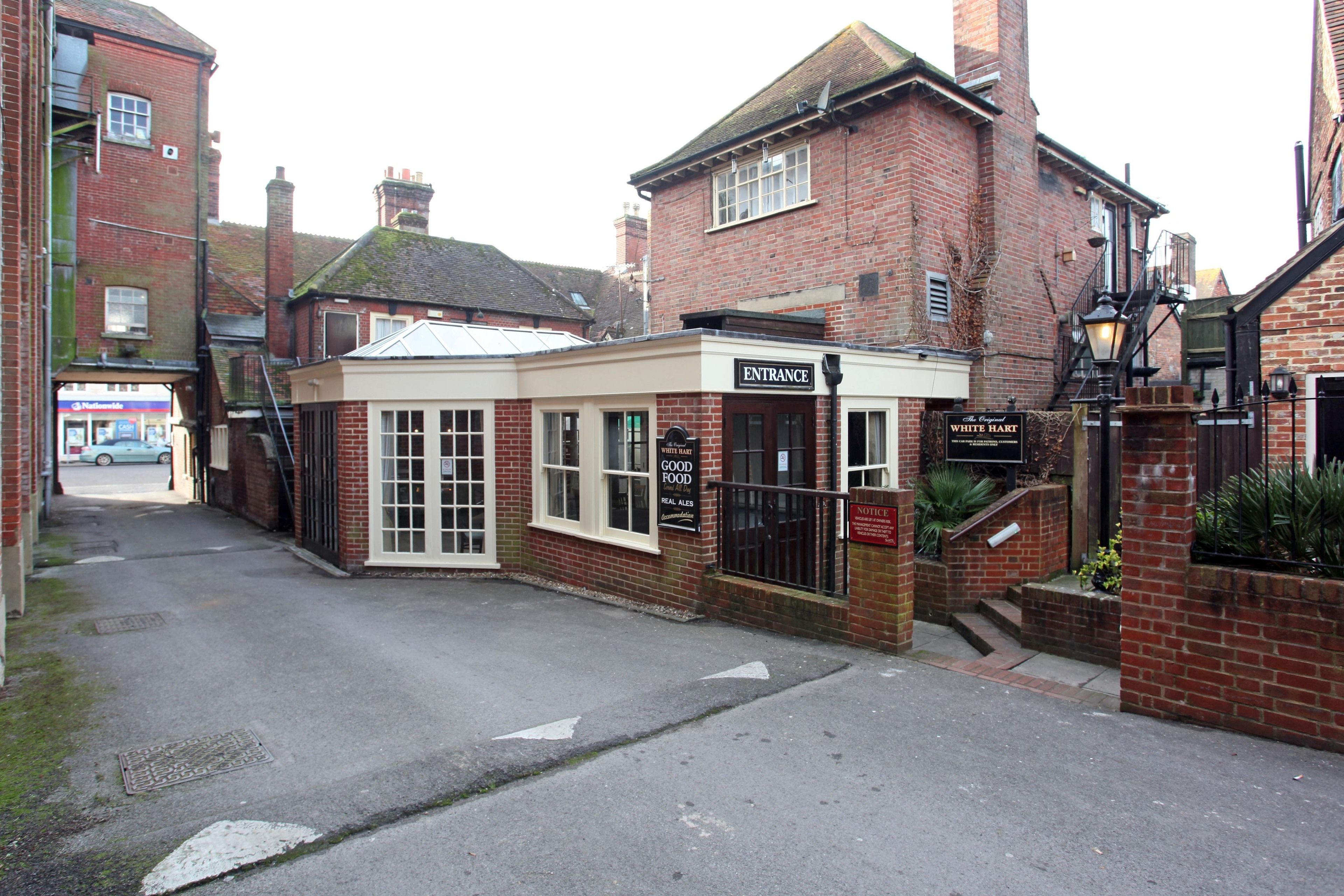 A brick building with a sign reading "Entrance" and "The Real White Hart" indicating a pub or restaurant.