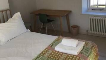 Una habitación de hotel con una cama grande, un escritorio y una silla.