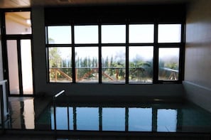 Une piscine avec vue sur un balcon et des arbres.