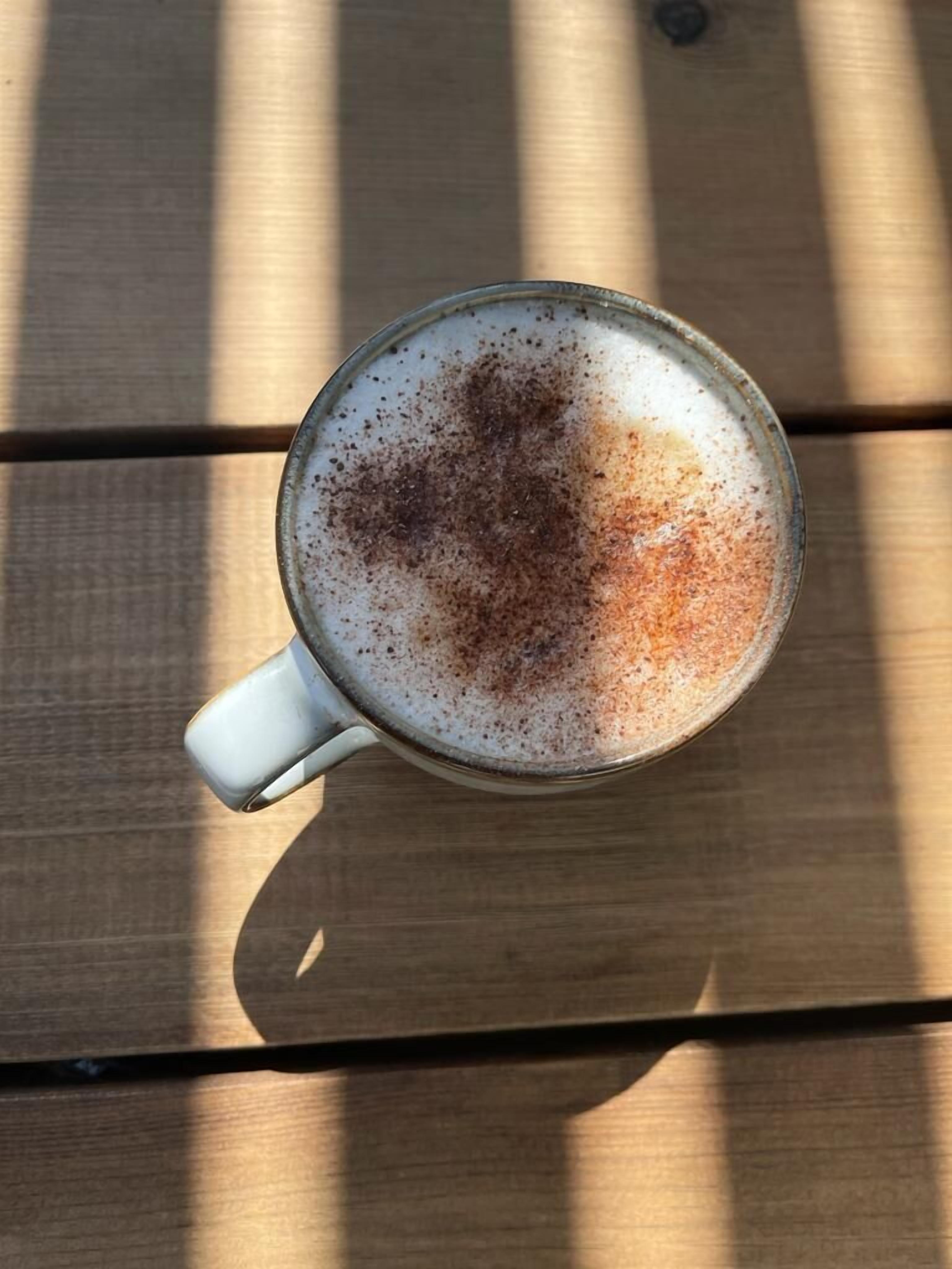 Una taza de café sobre una mesa de madera.