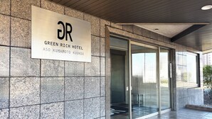 A modern hotel entrance with a sign for the Green Rich Hotel. - Green Rich Hotel Aso Kumamoto Airport Artificial Hot Spring Futamata Yunohana (Kikuyo)