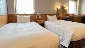 A hotel room with two beds, a desk, a chair, a mirror, and a window with curtains. - Green Rich Hotel Aso Kumamoto Airport Artificial Hot Spring Futamata Yunohana (Kikuyo)