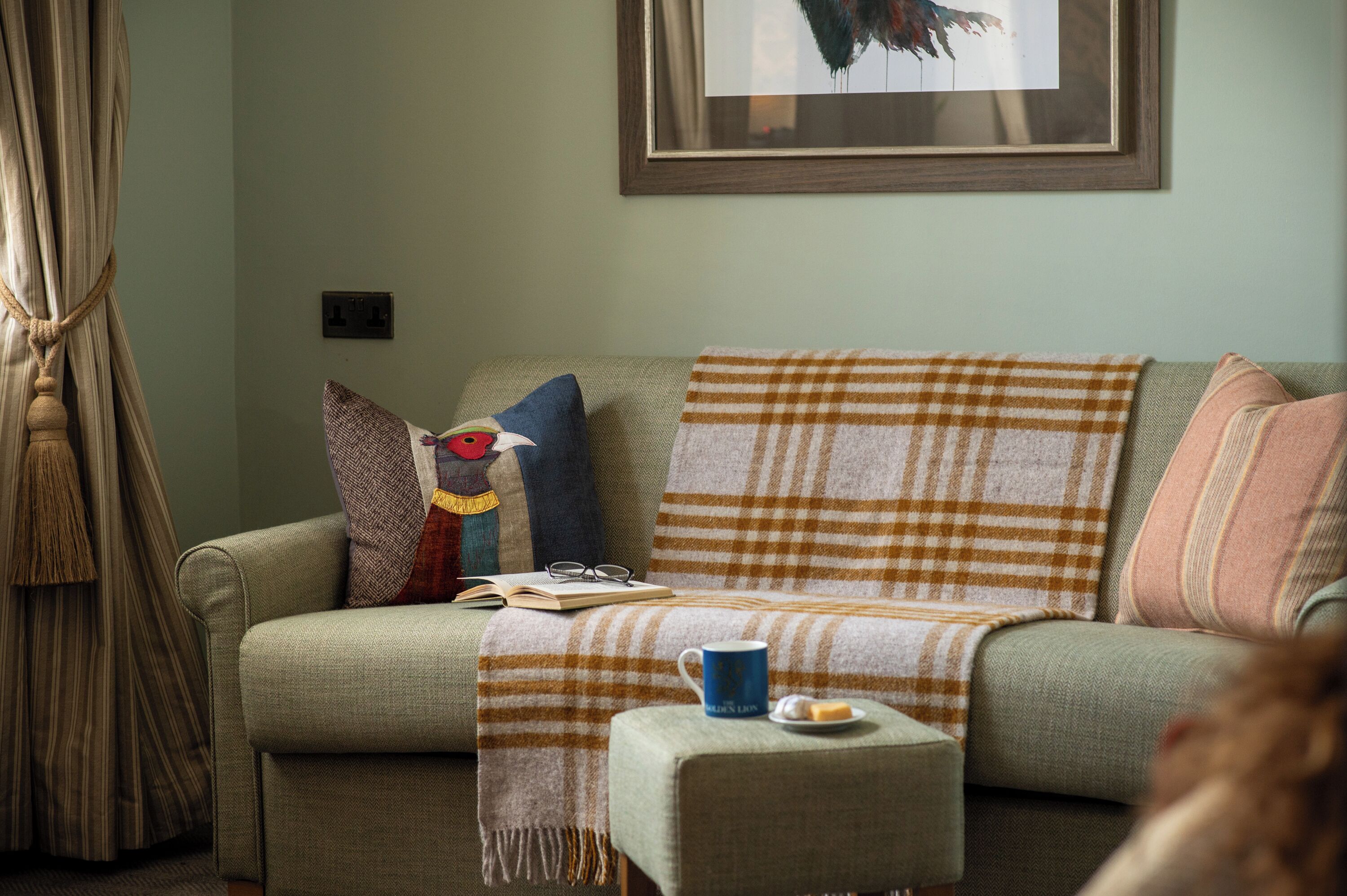 A cozy living room with a sofa, a coffee table, and a framed picture on the wall.