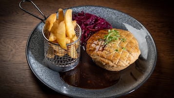 A plate with a burger, fries, and red cabbage.