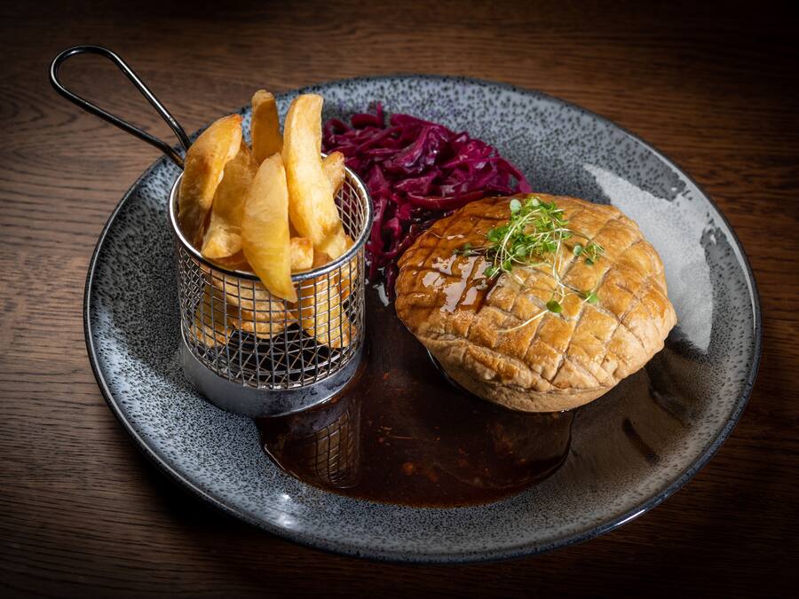 A plate with a burger, fries, and red cabbage.