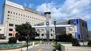 A modern building with a prominent sign reading 'ハイネスホテル' and a smaller sign for 'ハイネスホテルリゾート'. - Highness Hotel Kurume (Kurume)