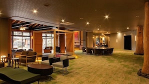 A spacious lobby with a mix of seating areas, a bar, and a view of the outdoors. - Arden Hotel Aso (Minamiaso)