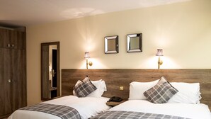 A hotel room with two beds, a wardrobe, and two wall-mounted mirrors. - The Sitwell Arms Hotel (Sheffield)