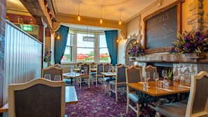 A restaurant with wooden furniture, a chalkboard menu, and a stone fireplace. - The Sitwell Arms Hotel (Sheffield)