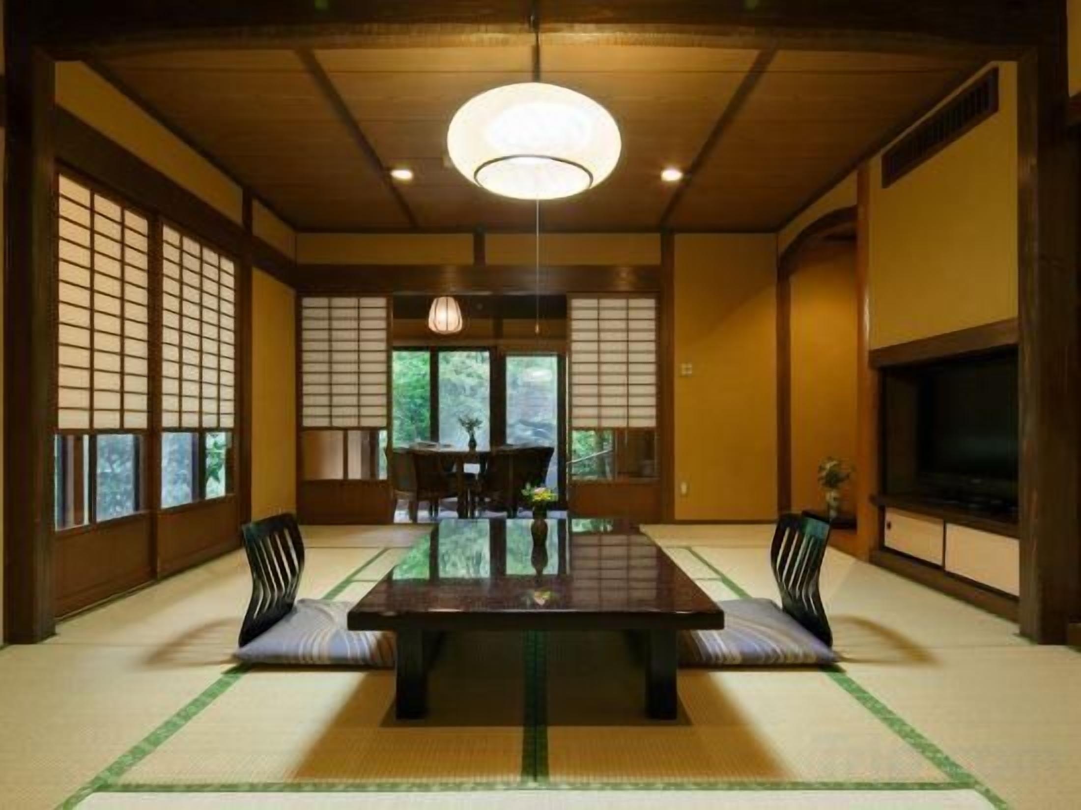 Una habitación tradicional japonesa con suelo de tatami, una mesa baja y puertas correderas.