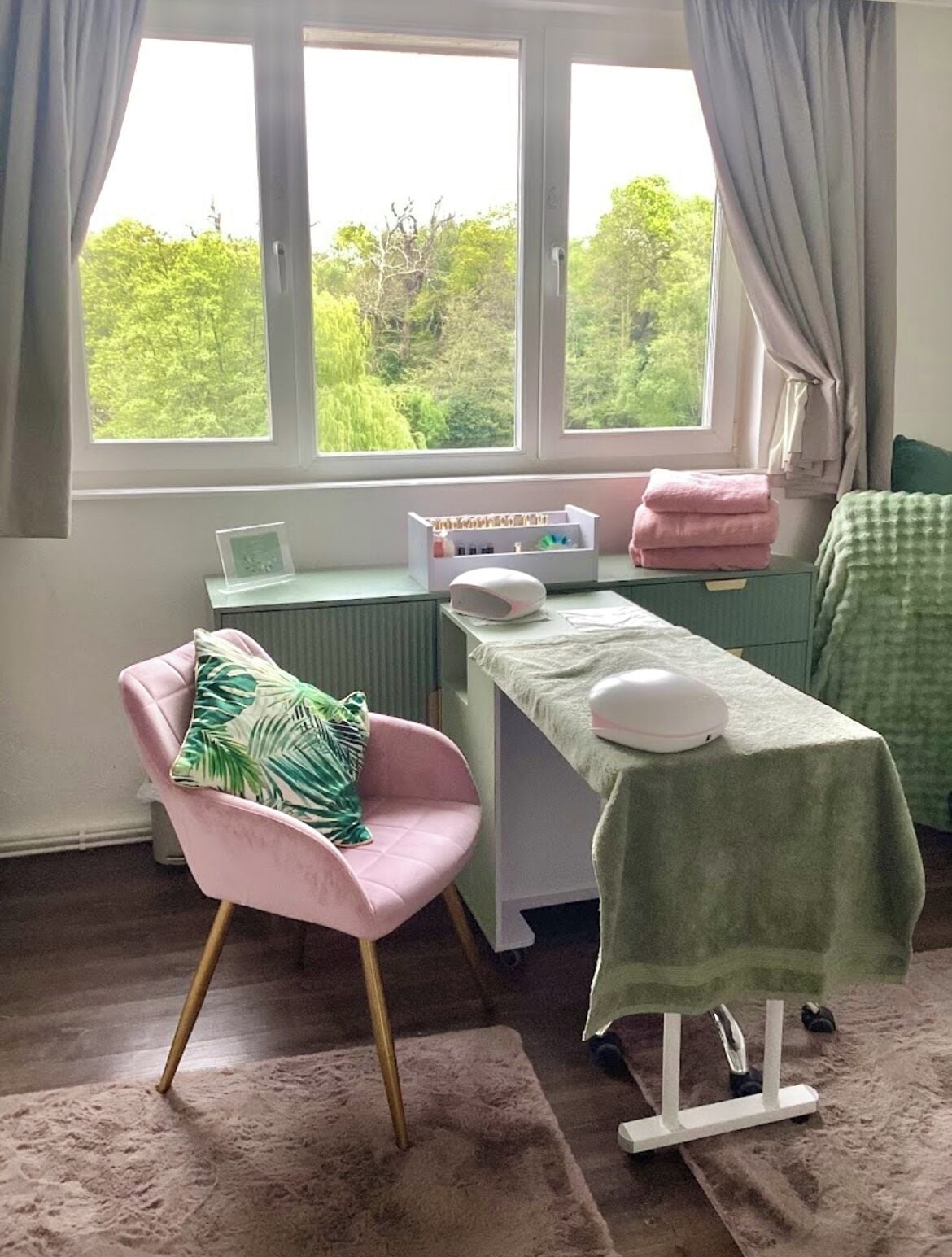 A room with a chair, a table, a radiator, and a window with curtains.