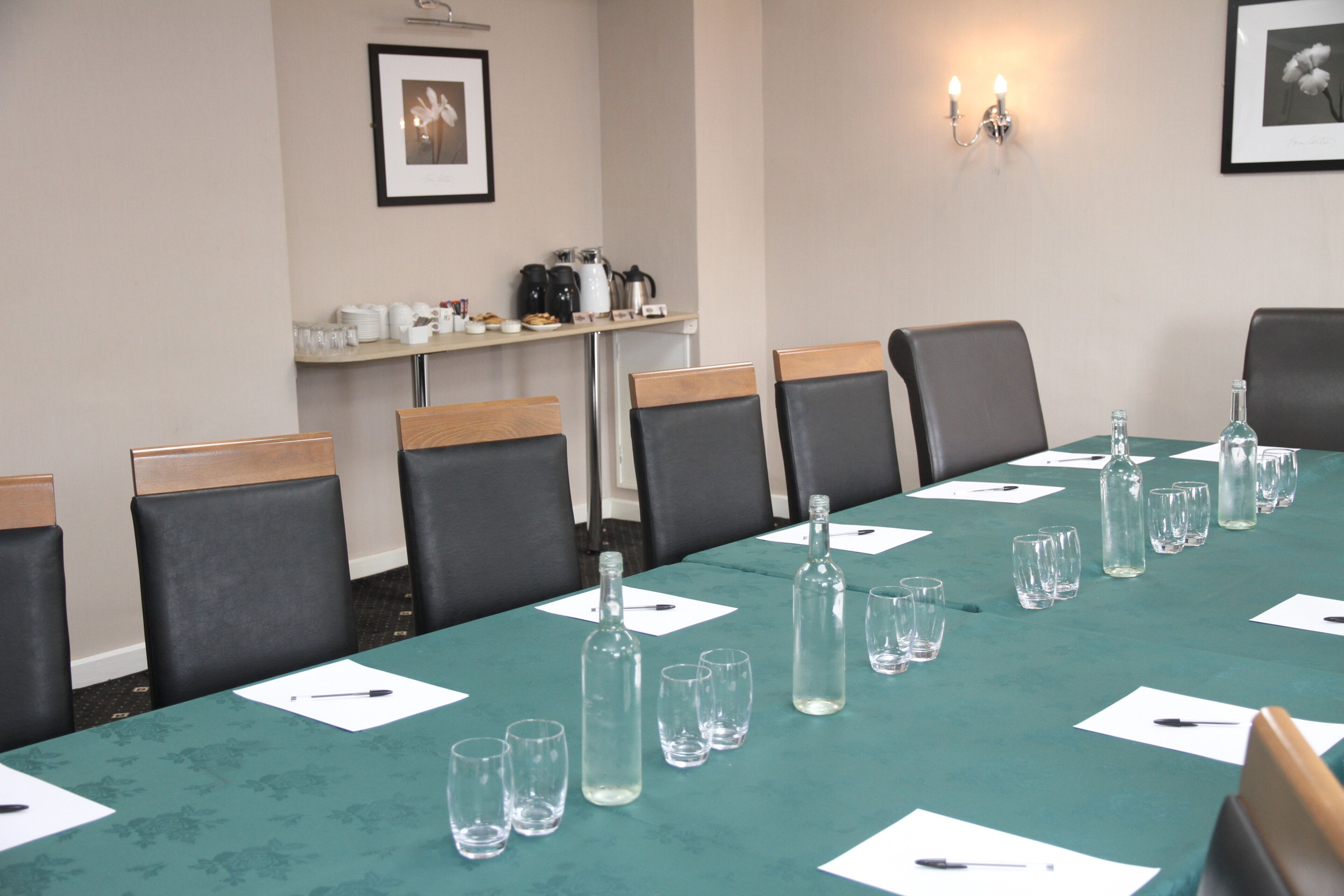 Une salle de conférence équipée d’une longue table, de chaises et d’un coin café.