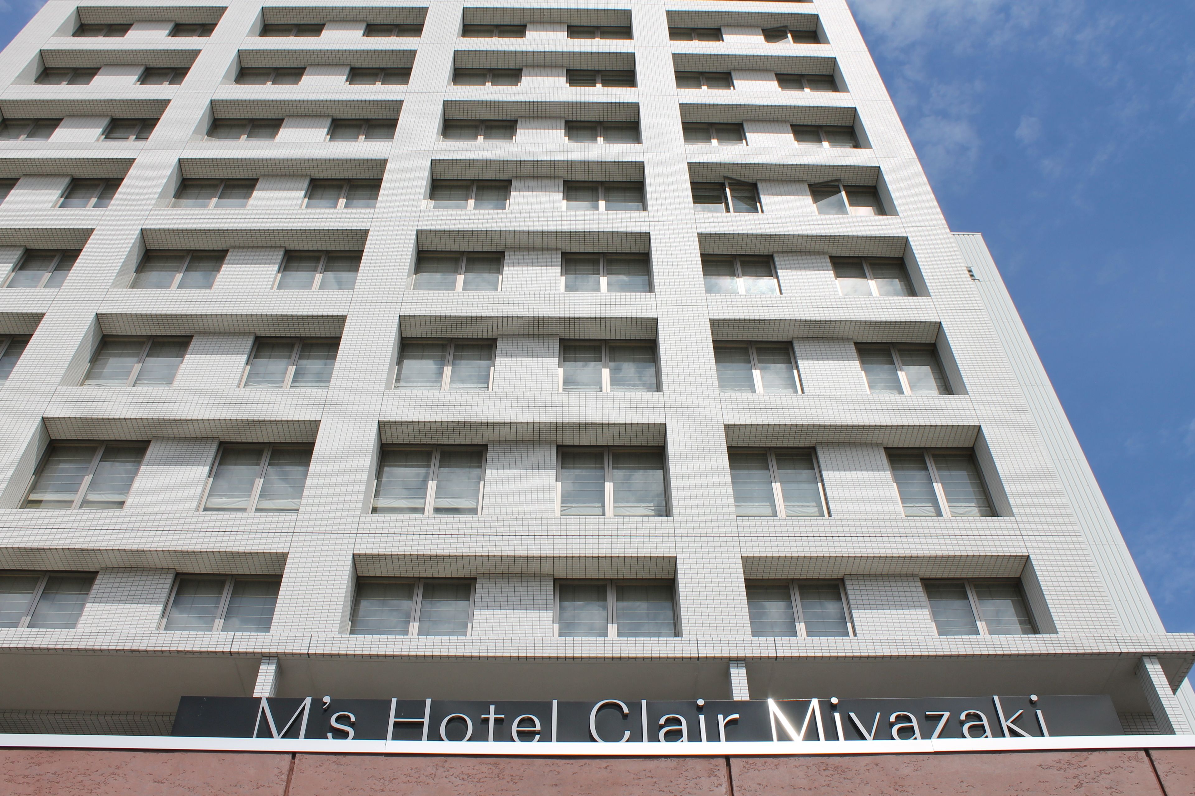 A tall hotel building with multiple floors and a sign reading "M's Hotel Clair Mivazaki".