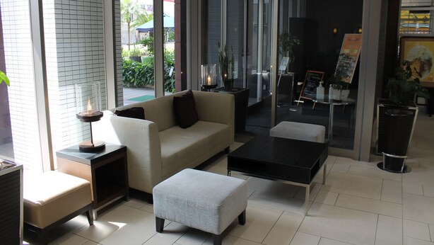 A modern hotel lobby with a sofa, coffee table, and side tables. - M's Hotel Clair Miyazaki (Miyazaki)
