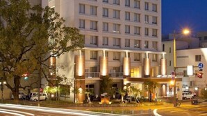 A multi-story hotel with a modern design, featuring a prominent entrance with illuminated columns and a well-lit facade. - M's Hotel Clair Miyazaki (Miyazaki)