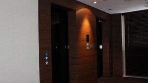 An elevator with a digital display, wooden paneling, and a carpeted floor. - M's Hotel Clair Miyazaki (Miyazaki)