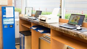 A reception desk with computers, a printer, and a blue information kiosk. - Toyoko Inn Miyazaki Ekimae (MIYAZAKI)