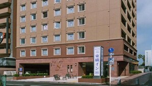 A multi-story hotel with a uniform facade, a visible entrance, and a sign indicating the name and address. - Toyoko Inn Miyazaki Ekimae (MIYAZAKI)