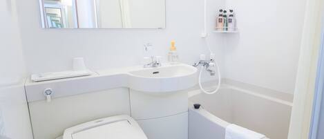 A modern bathroom with a toilet, sink, and bathtub.