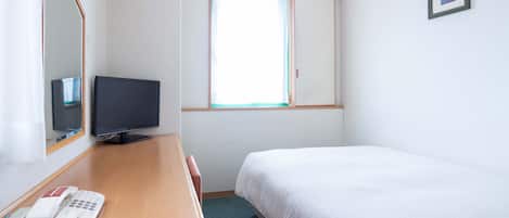 A hotel room with a bed, a desk with a telephone and a television, a window with curtains, and a framed picture on the wall.
